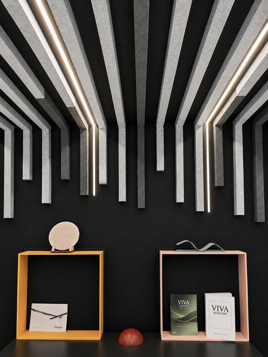 Detalle de pared acústica Viva Acoustic con paneles fonoabsorbentes verticales e iluminación LED lineal integrada sobre fondo negro corporativo