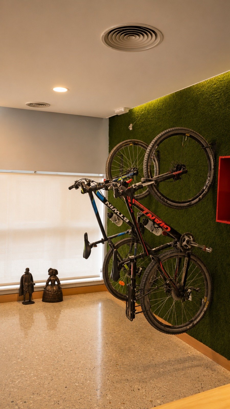 Recepción Hotelera — zona funcional con servicio para bicicletas integrado en pared verde natural